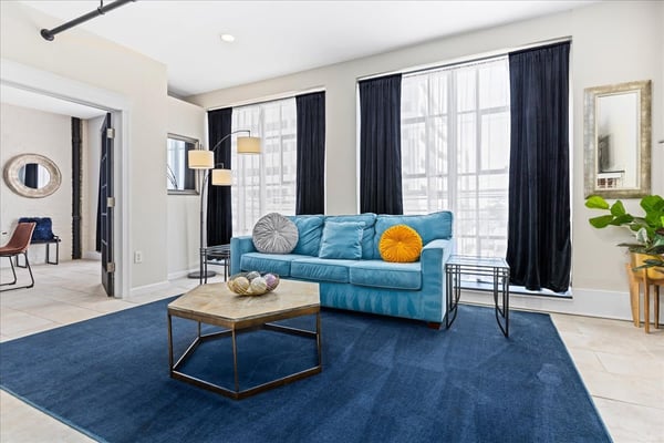 Bright blue living room with large windows