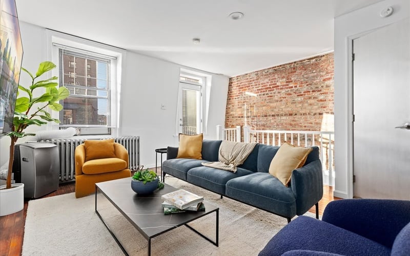 Living room with exposed brick wall and navy sofa