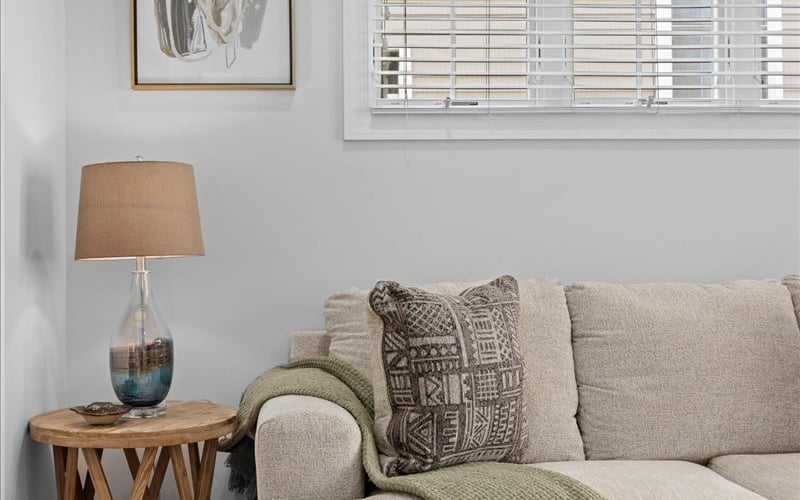 Neutral sofa corner with green throw and side table