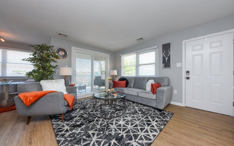 Grey living room with orange accents and patterned rug