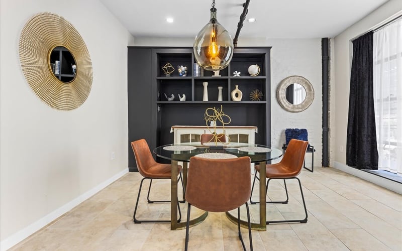 Styled dining room with leather chairs and gold pendant light